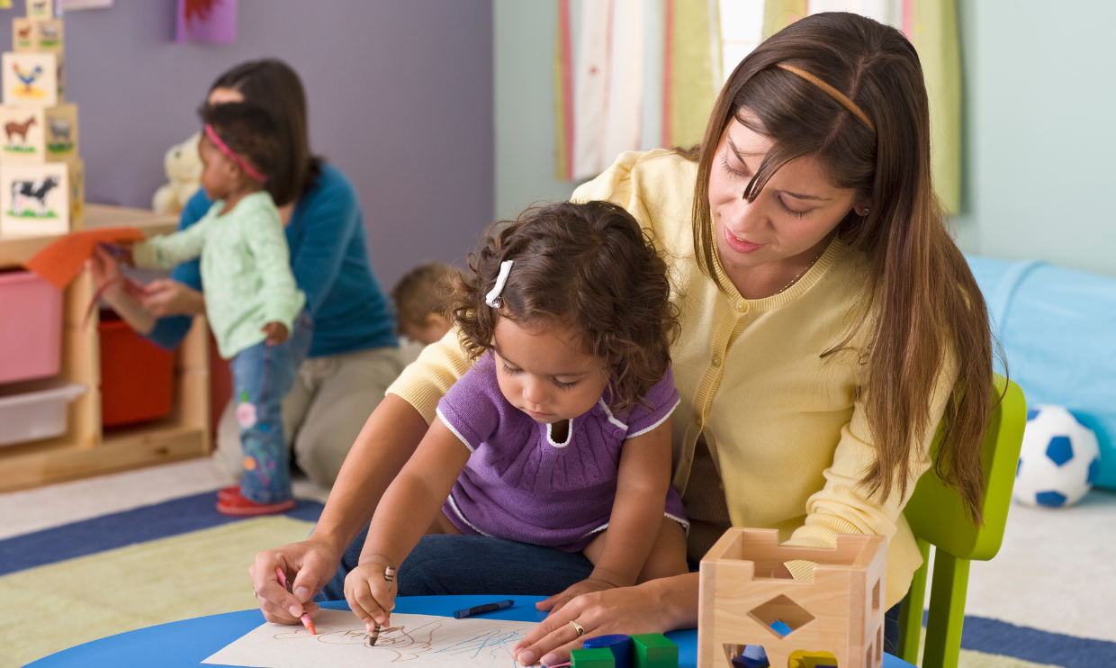 Adults helping young children in early childhood education setting