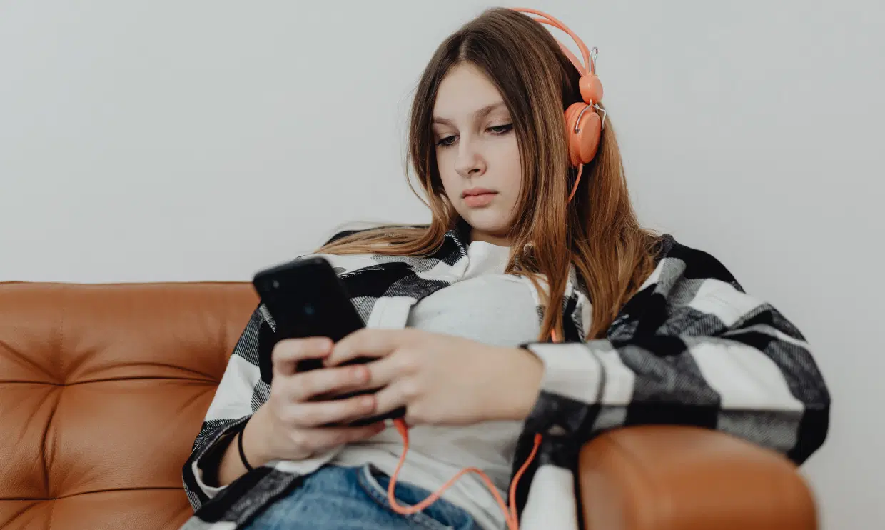 Teenager with headphones and phone