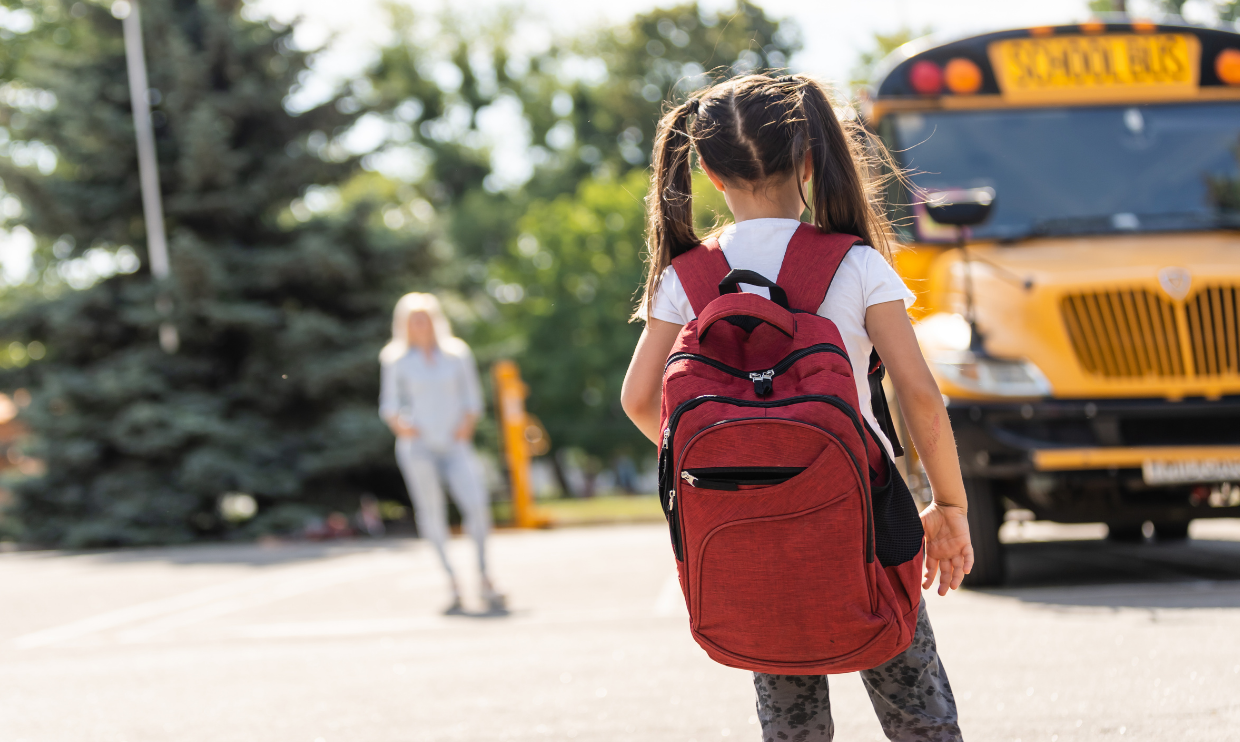 Child in front of school bus